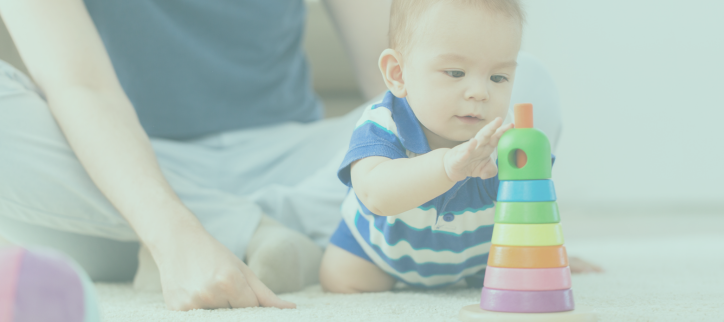 a baby playing with a colorful toy on the floor