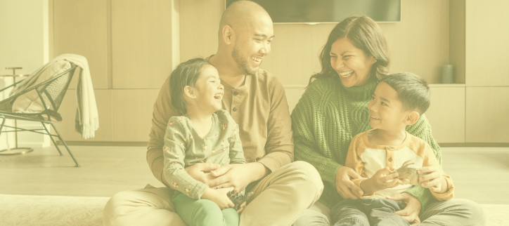 A family sitting on the floor in a living room