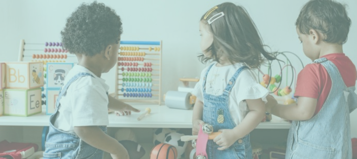 three children playing with toys in a classroom