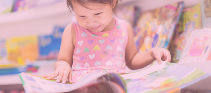 a child is reading a book in a library