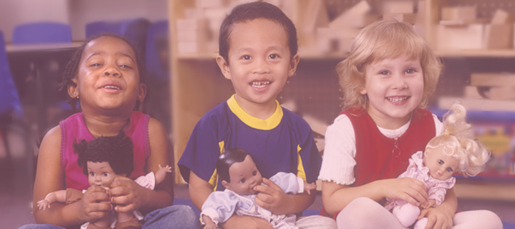 a group of children sitting on the floor holding dolls