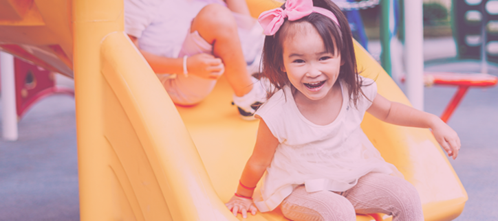 a child sitting on a slide at a playground