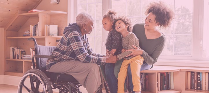 A person sitting in a wheelchair with two children and another person