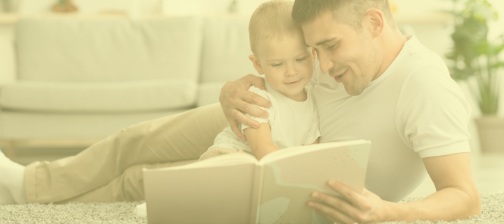 a person and child reading a book on the floor