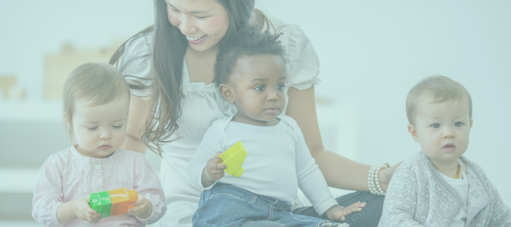 Three babies sitting on the floor with teacher