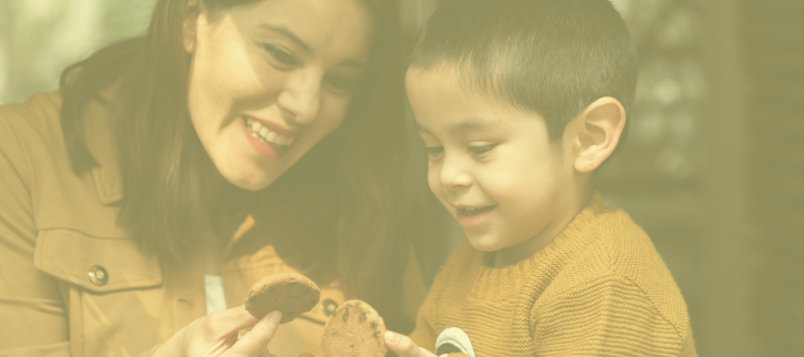 a person holding a cookie to a child