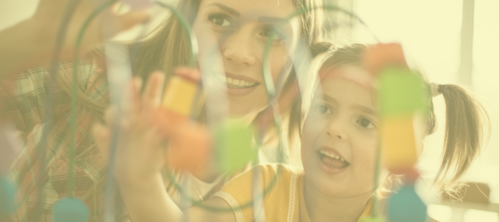 A parent and child playing with colorful toys